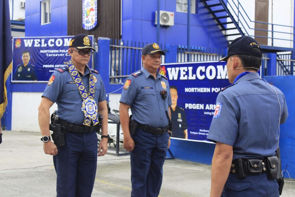 May be an image of 5 people, ambulance and text that says 'WELCOM NORTHERN NORTHERNPOLIC POLI Turnover PMGEN ANTHO PUL WELCOM NORTHERN POL PBGEN ARN Acting PO Morthere Tanigaa Street'