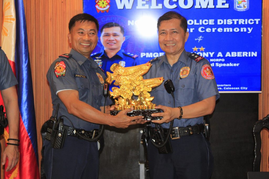 May be an image of 3 people and text that says 'WELCOME NCRPO OLICE DISTRICT ar Ceremony PMGE ONY A ABERIN NORPO d Speaker م ve.CaleecanCity ve. Caleccan City'