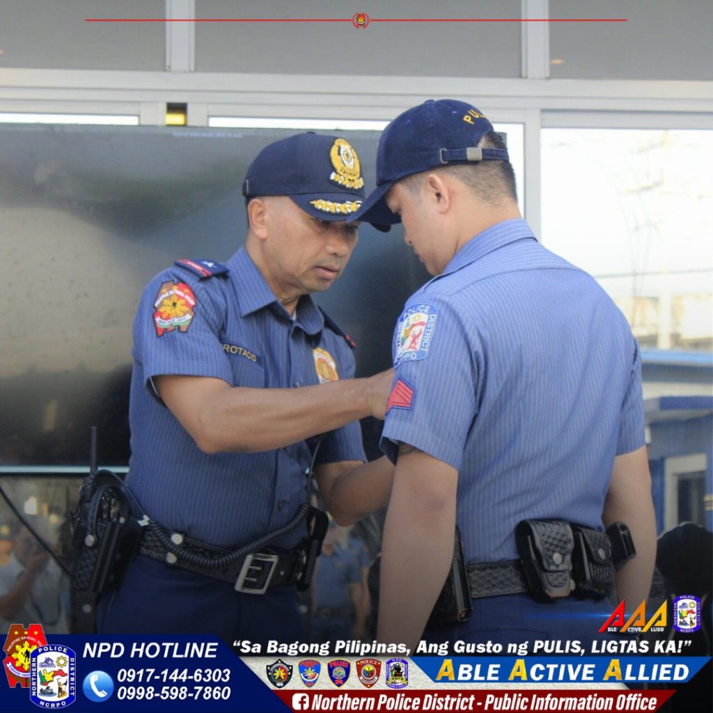 May be an image of 2 people, ambulance and text that says 'ROT ACIO POLIO NPD HOTLINE 0917-144-6303 0998-598-7860 AAAG "Sa Bagong Pilipinas, Ang Gusto ng PULIS, LIGTAS KA!" ABLE ACTIVE ALLIED f Northern Police District Public Information Office'